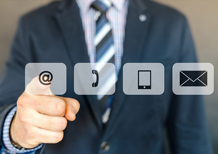 Ein Mann im Anzug drückt auf eines von vier Kontakt-Icons im Vordergrund des Bildes.